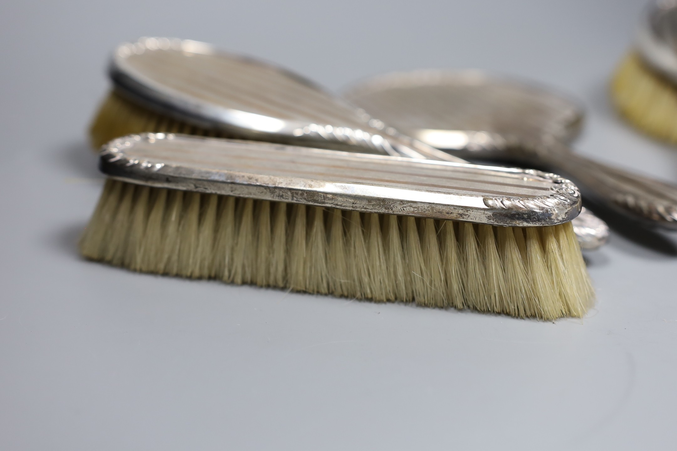 A George V silver and yellow metal five piece dressing table mirror and brush set, by Charles & Richard Comyns, London, 1924.